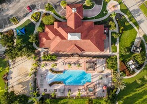 An aerial view of a hotel with a swimming pool, a covered area with seating, and a parking lot. - Upstay - 18-guest Mansion w Pool, Games, Cinema (Kissimmee)