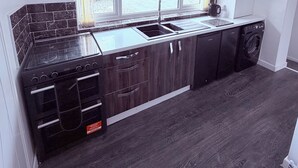 A modern kitchen with a built-in stove, a sink, and a dishwasher. - 2 bedroom full referbished anex, sleeps 4. Kitchen, Cooker, fridge/freezer. (bradford)