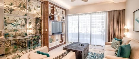 Un salon moderne comprenant un téléviseur, un canapé, une table basse et des panneaux muraux décoratifs.