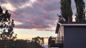 A residential area with a garage, a vehicle, and a house with a balcony. - Breathtaking views surrounding this home, perfect for a relaxing getaway! (Cody)