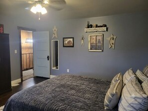 Un dormitorio con cama, puerta y adornos en la pared.