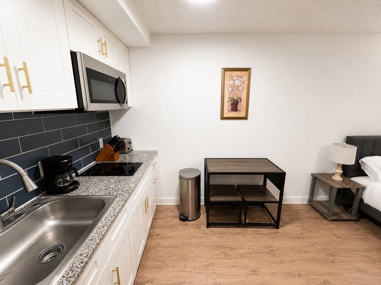 A compact kitchen with a microwave, sink, and coffee maker.
