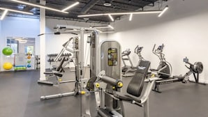 A gym with various exercise machines, including a leg press and a stationary bike.