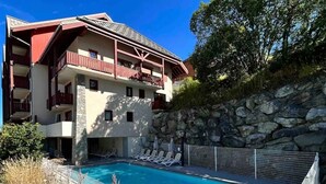 Et hotel med swimmingpool, stenvægge og balkon.
