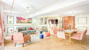 Ein modernes Wohnzimmer mit Sofa, Couchtisch und Essbereich mit Stühlen.