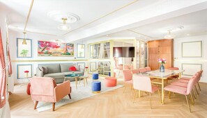 Een moderne woonkamer met een bank, salontafel en een eethoek met stoelen.