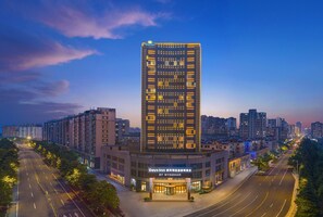 Un hotel moderno de gran altura, con fachada contemporánea, varios pisos y una entrada destacada.