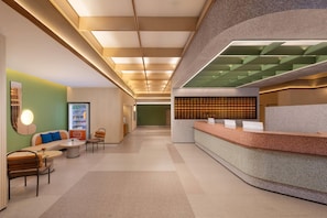 A modern reception area with a counter, seating, and a wall-mounted display.