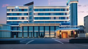 A multi-story hotel building with a prominent vertical structure and a sign indicating it's a Days Inn by Wyndham.
