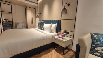 Una habitación de hotel con cama, mesita de noche y una silla.