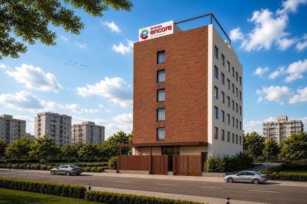 A modern building with a prominent sign for Ramada Encore by Wyndham. - Ramada Encore by Wyndham Vrindavan Rukmani Vihar (Vrindavan)