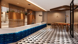 A modern interior with a reception desk, seating area, and patterned flooring. - Ramada Encore by Wyndham Vrindavan Rukmani Vihar (Vrindavan)
