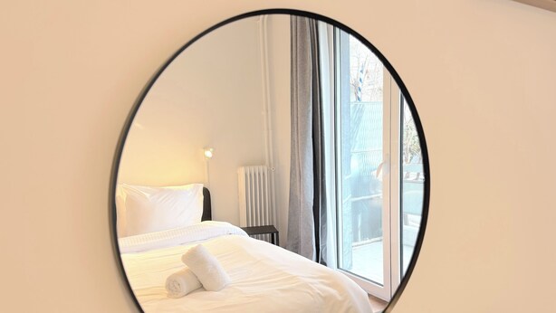 A hotel room with a bed, a nightstand, a lamp, and a window. - 1BR next to Pasalimani, Marina Zeas & Hospital (Pireas)