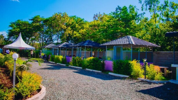 A garden area with a gazebo, covered seating areas, and a gravel path.