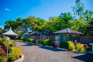 A garden area with a gazebo, covered seating areas, and a gravel path.