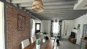 Ein geräumiger Essbereich mit Holztisch, Stühlen und einer hängenden Korbscharnik.