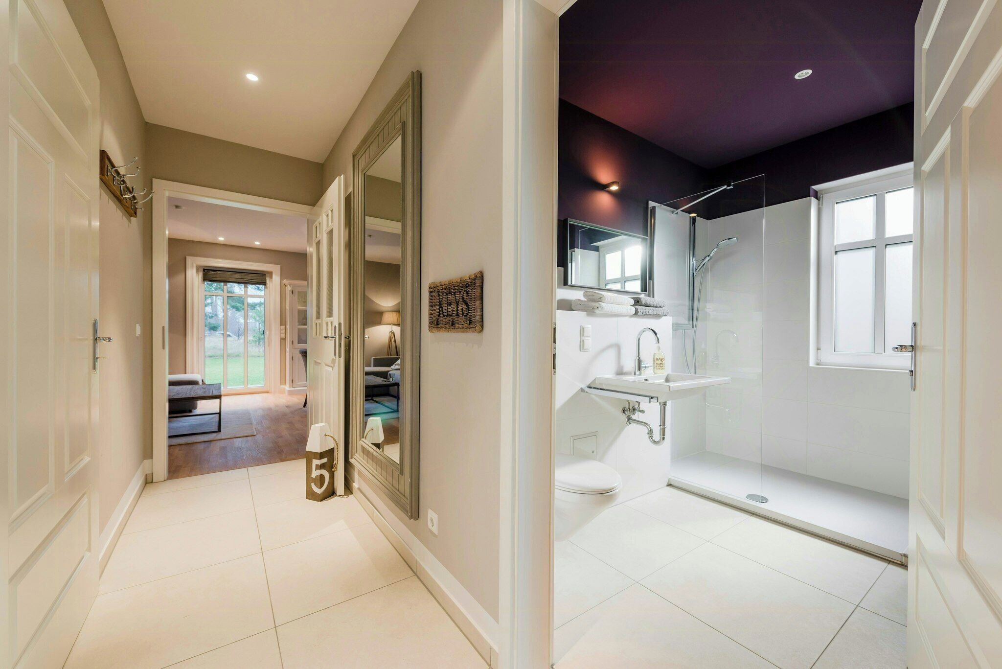 Une salle de bain moderne avec une douche à parois de verre, un lavabo blanc et des toilettes.