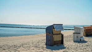 Strandstühle am Strand gestapelt, nahe am Wasser.
