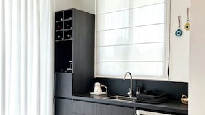 A modern kitchen with a built-in oven, a sink, and a window with blinds. - NOAM by the sea Ocean View Suite #4 Adults Only (Tamarindo)