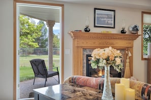 A room with a fireplace, a sofa, a table, and a chair.