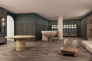 Un intérieur moderne avec un espace salon central, une grande table et un comptoir d’accueil.