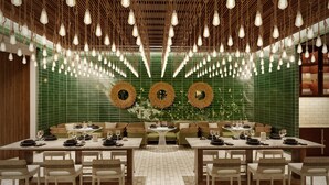 A restaurant with multiple dining tables, hanging light fixtures, and green tiled walls. - Andaz Turks And Caicos At Grace Bay (Providenciales)