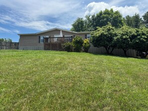 A residential house with a fenced yard, a wooden deck, and a large tree. - Overlook Nook, 3-bedroom house in charming Kodak (Kodak)