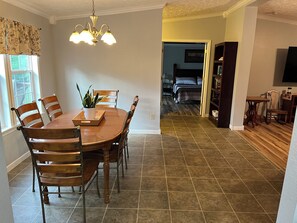 A dining area with a wooden table and chairs, a chandelier, and a potted plant. - Overlook Nook, 3-bedroom house in charming Kodak (Kodak)