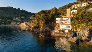 A coastal building with multiple balconies, situated on a rocky cliff overlooking the sea. - Villa Il Faro 10, Emma Villas (Scaglieri)