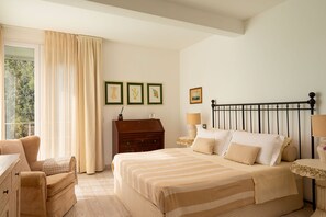 A bedroom with a bed, a dresser, a nightstand, a lamp, and a window with curtains. - Villa Il Faro 10, Emma Villas (Scaglieri)