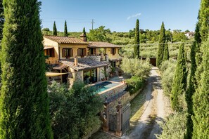 A villa with a swimming pool, surrounded by tall cypress trees and a gravel path. - Colle Calzolaro 8, Emma Villas (Tavernelle)
