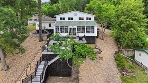 A two-story house with a covered porch, a staircase leading to the upper level, and a small garden area. - Private Dock, Boat & PWC Slips, Fire Pit, Lake Views (Rocky Mount)