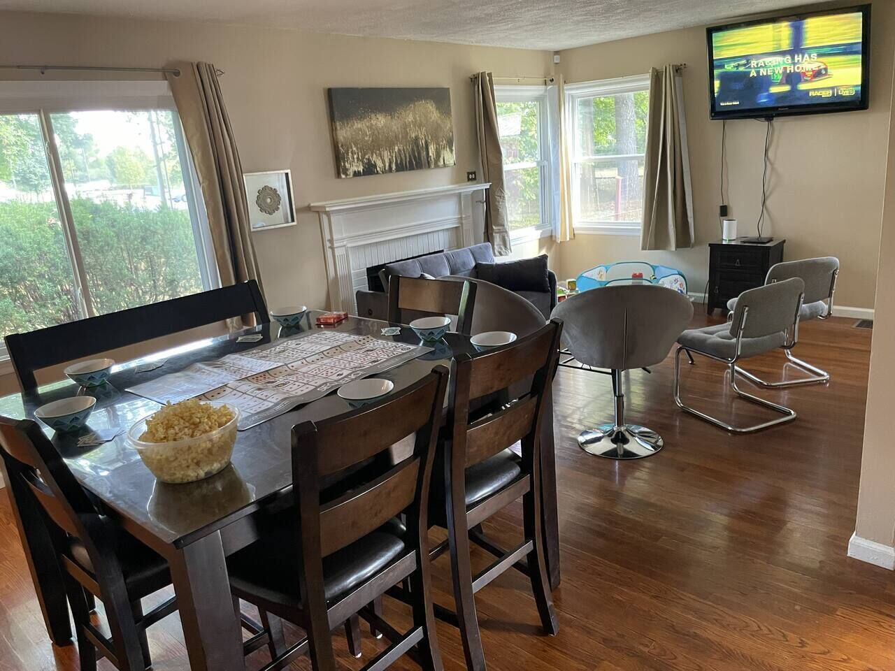 A dining area with a wooden table, chairs, and a bowl of food.