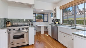 Una cocina moderna con horno integrado, un lavamanos y un ventanal con vistas al exterior.