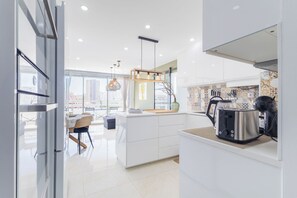 Eine moderne Küche mit einer großen Kochinsel, einem Toaster und Blick auf die Stadt.