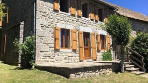 A stone building with wooden shutters, a chimney, and a staircase leading to the entrance. - Camillou's House (PRINSUEJOLS)
