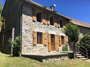 Ein Steinhaus mit Holzhörnern, einem Schornstein und einer Treppe zum Eingang.