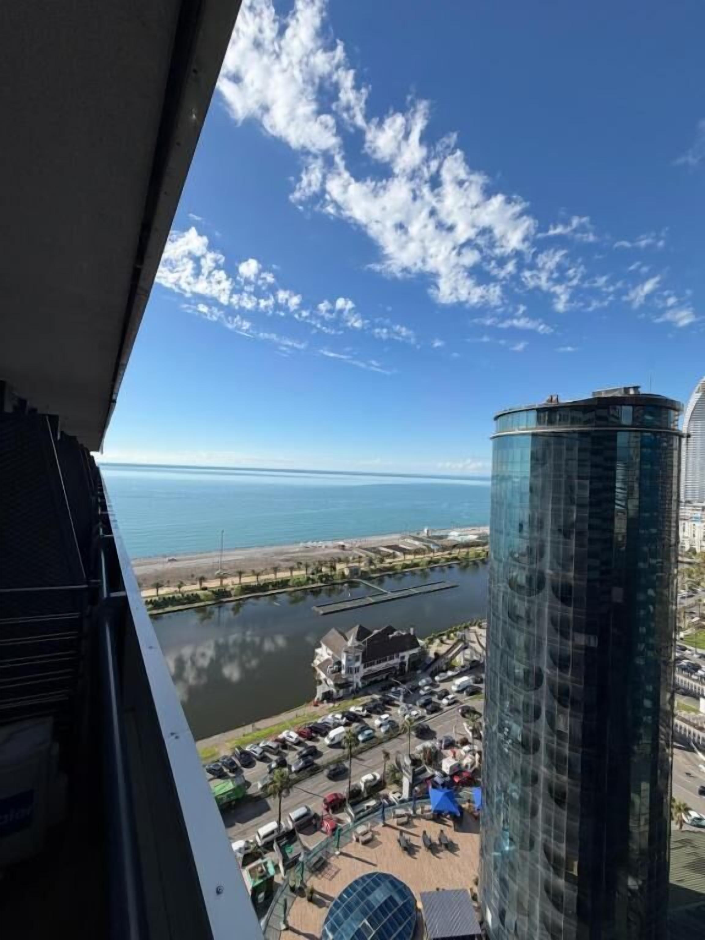 Een hoog gebouw met uitzicht op een wateroppervlak en een jachthaven.