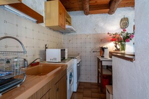 Una cocina compacta equipada con lavadora, microondas y fregadero.