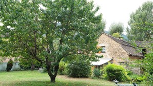 A stone house with a garden, a large tree, and a bird bath. - Domaine Rivière (6–7 people) (BRENOUX)
