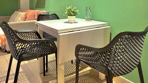 A dining area with a table, chairs, and decorative wall art. - Isabel Suites By YellowKey (Santo Domingo)