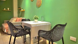 A dining area with a table, chairs, and a potted plant. - Isabel Suites By YellowKey (Santo Domingo)