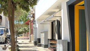 A street with a tree, a parked truck, and a building with a yellow door. - Isabel Suites By YellowKey (Santo Domingo)