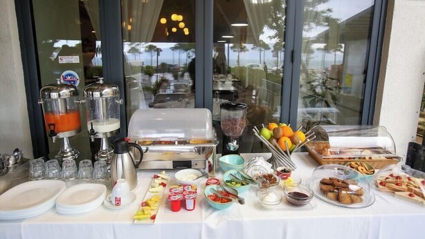 Un buffet proposant une variété de plats, un coin café et un distributeur de jus.