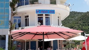 Un bâtiment sur lequel on peut lire l’inscription « MARE BLU », et qui possède un balcon avec une balustrade.