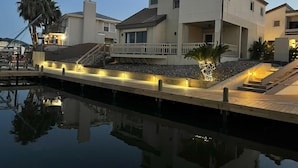 A waterfront property with a dock, a pool, and a multi-level house with a balcony. - DaZzling Waterfront 3-bedroom Pool/Hot tub/Gym in N. Padre Island (Corpus Christi)