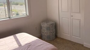 Un dormitorio con cama, ventana, ventilador de techo y armario.