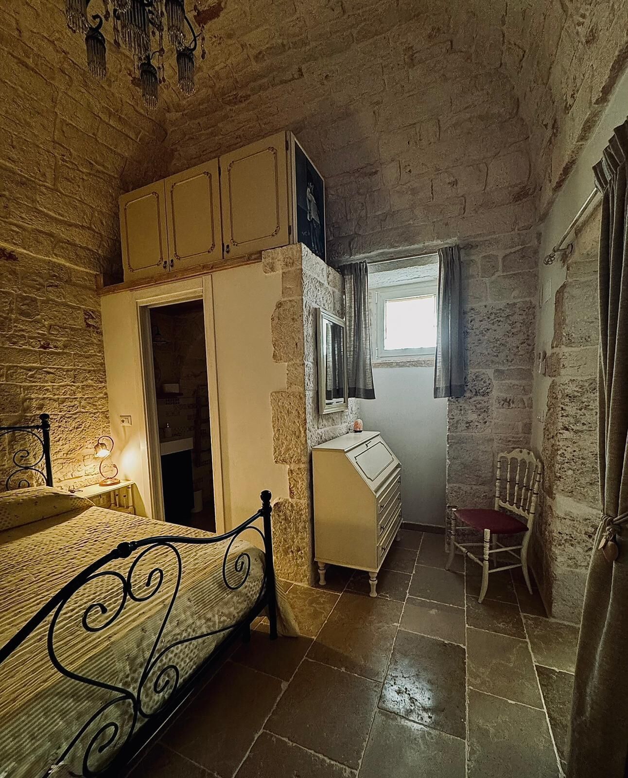 A bedroom with a bed, a dresser, a chair, a desk, and a window.