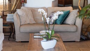 A living room with a sofa, a coffee table with a plant, a staircase with a railing, and a lamp. - Villa Melioris, Divine Sea Views, Private Pool, Spacious Furnished Terrace,. (Corfu)