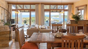 A dining area with a wooden table, chairs, and a view of the sea. - Villa Melioris, Divine Sea Views, Private Pool, Spacious Furnished Terrace,. (Corfu)